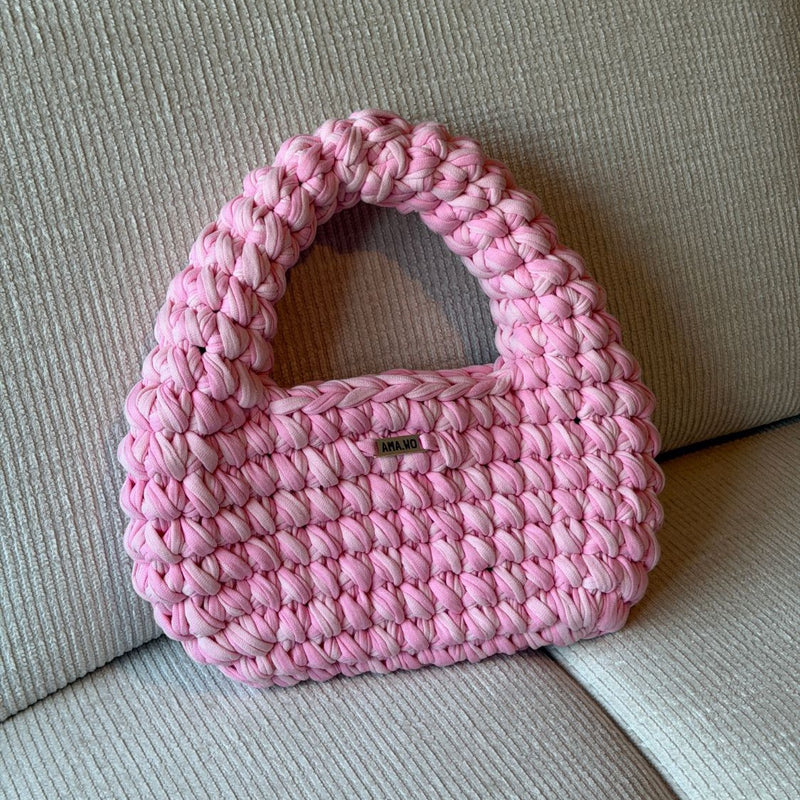 Sac Hana crocheté main, rose, sur un canapé